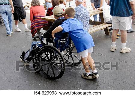 Grandson pushes grandfather in a wheelchair View Large Photo Image Stock Image - Grandson pushes grandfather in a wheelchair. Fotosearch