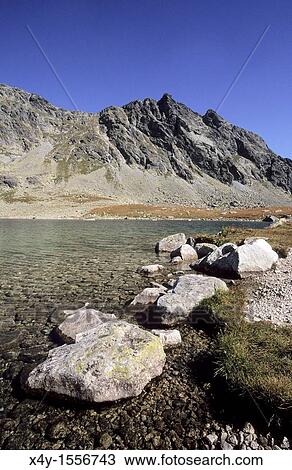 Stock Image - Granite boulders on the shore of the largest tarn in High Tatras Slovakia - Velke Hincove pleso. Fotosearch