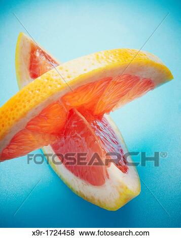 Grapefruit pieces in blue background View Large Photo Image Stock Photo - Grapefruit pieces in blue background. Fotosearch