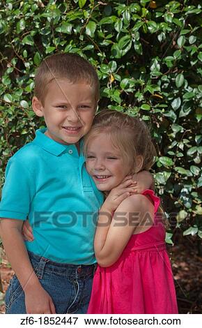 Great happy portrait of sister age 3 and brother age 5 at home in yard hugging and caring for each other View Large Photo Image Stock Photo - Great happy portrait of sister age 3 and brother age 5 at home in yard hugging and caring for each other. Fotosearch