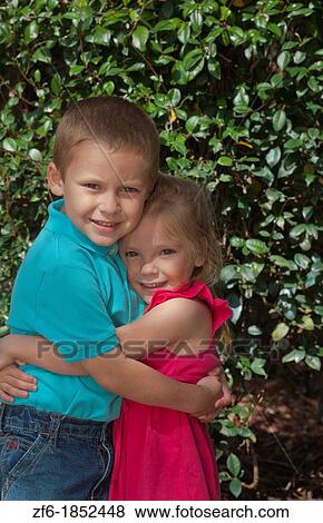 Great happy portrait of sister age 3 and brother age 5 at home in yard hugging and caring for each other View Large Photo Image Stock Photo - Great happy portrait of sister age 3 and brother age 5 at home in yard hugging and caring for each other. Fotosearch