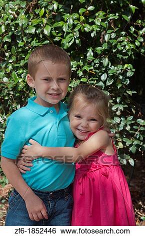 Great happy portrait of sister age 3 and brother age 5 at home in yard hugging and caring for each other View Large Photo Image Stock Photograph - Great happy portrait of sister age 3 and brother age 5 at home in yard hugging and caring for each other. Fotosearch