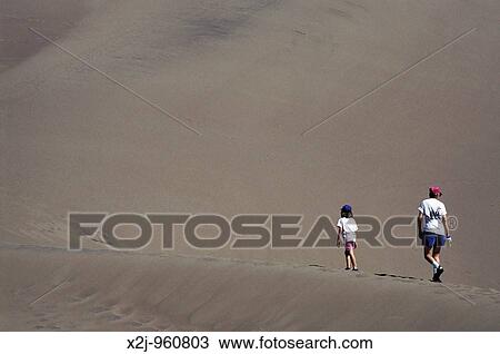 Great Sand Dunes National Monument, Colorado - A mother and her daughter climb a sand dune The dunes cover 30 square miles and rise more than 750 feet high View Large Photo Image Stock Image - Great Sand Dunes National Monument, Colorado - A mother and her daughter climb a sand dune The dunes cover 30 square miles and rise more than 750 feet high. Fotosearch