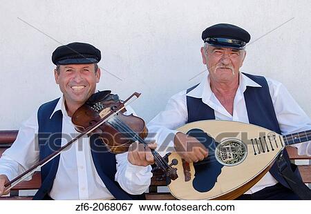 Stock Photo - Greece Santorini Oia Cyclades band playing music with guitar and violin musical.. Fotosearch