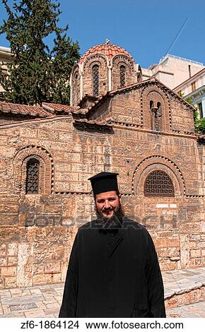 Greek Orthodox Priest in Plaka area of Athens Greece with shopping and stores and 11th Century Byzantine Cathedral View Large Photo Image Picture - Greek Orthodox Priest in Plaka area of Athens Greece with shopping and stores and 11th Century Byzantine Cathedral. Fotosearch