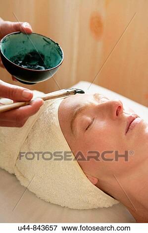 Stock Photo - Green clay face skin theraphy massage, woman. Fotosearch