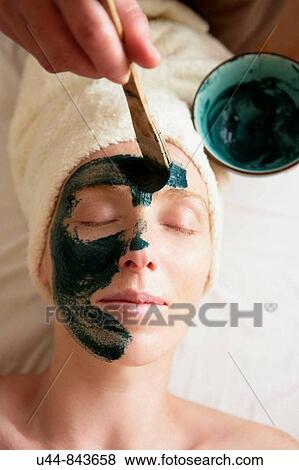 Stock Photo - Green clay face skin theraphy massage, woman. Fotosearch
