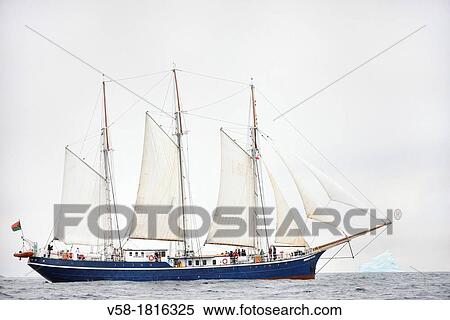 Stock Photography - Greenland, Melville Bay, Cape York, Schooner Rembrandt Van Rijn cruising along a 50 m high iceberg. Fotosearch