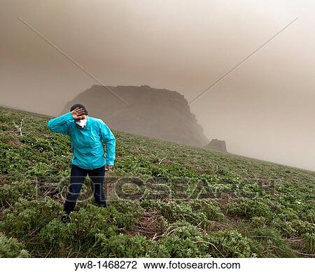 Stock Image - Grimsvotn Volcanic Eruption in the Vatnajokull Glacier, Iceland Woman wipes the ash from her eyes. Fotosearch