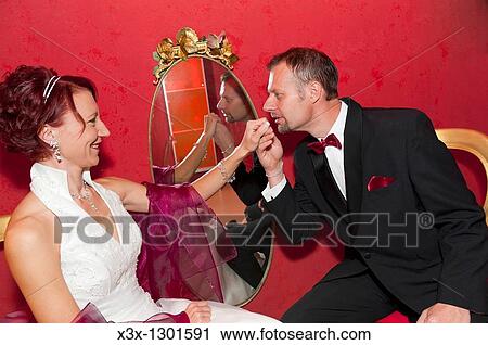 Groom gallantly kissing bride's hand View Large Photo Image Stock Image - Groom gallantly kissing bride's hand. Fotosearch