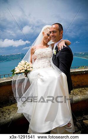 Groom holding bride in front of a Lake View Large Photo Image Stock Image - Groom holding bride in front of a Lake. Fotosearch