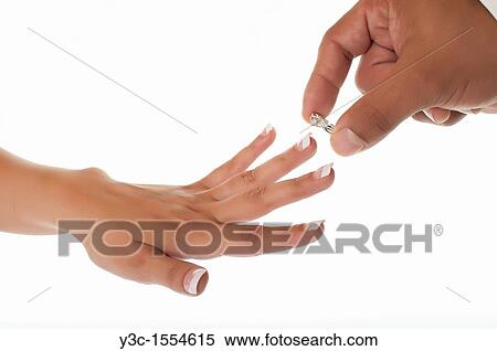 Stock Photography - Groom puts wedding ring on finger of the bride. Fotosearch