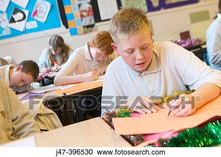 Group of 12 year old children, sitting in class, concentrating, drawing View Large Photo Image Stock Image - Group of 12 year old children, sitting in class, concentrating, drawing. Fotosearch