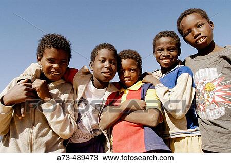 Stock Image - Group of boys in a small oasis between Ouadane and Chinguetti. Mauritania.. Fotosearch