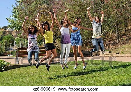 group of five girls jumping in the park with his arms raised View Large Photo Image Stock Photo - group of five girls jumping in the park with his arms raised. Fotosearch