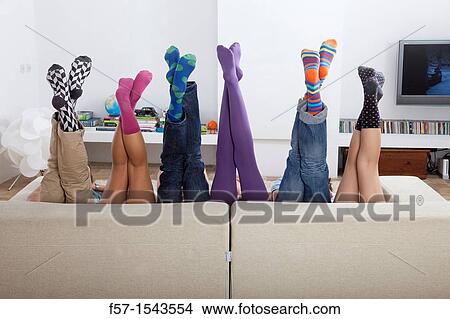 Group of friends legs sticking up over a sofa View Large Photo Image Picture - Group of friends legs sticking up over a sofa. Fotosearch