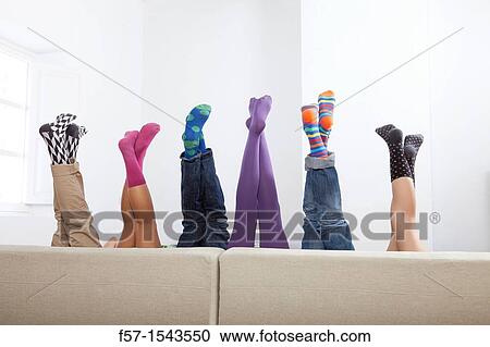 Group of friends legs sticking up over a sofa View Large Photo Image Stock Image - Group of friends legs sticking up over a sofa. Fotosearch