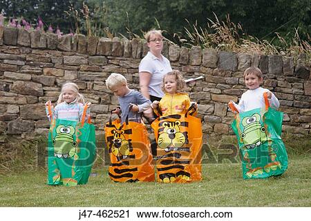 Group of pre school children standing in a line, waiting to start a sack race on sports day. View Large Photo Image Stock Image - Group of pre school children standing in a line, waiting to start a sack race on sports day.. Fotosearch