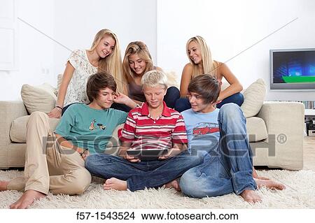 Group of teenagers communicating with a digital tablet View Large Photo Image Picture - Group of teenagers communicating with a digital tablet. Fotosearch