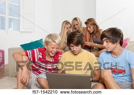 Group of teenagers communicating with a laptop View Large Photo Image Stock Image - Group of teenagers communicating with a laptop. Fotosearch
