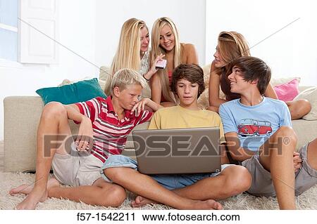 Group of teenagers communicating with a laptop View Large Photo Image Stock Image - Group of teenagers communicating with a laptop. Fotosearch