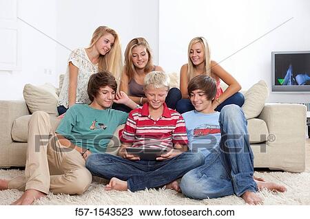 Group of teenagers communicating with a digital tablet View Large Photo Image Stock Image - Group of teenagers communicating with a digital tablet. Fotosearch