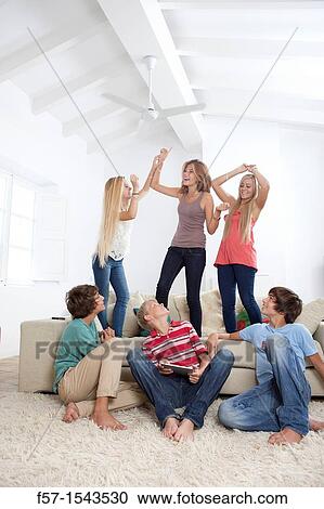 Group of teenagers dancing to music on a tablet View Large Photo Image Stock Image - Group of teenagers dancing to music on a tablet. Fotosearch