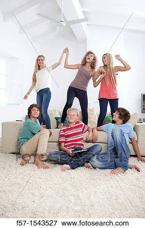 Stock Photo - Group of teenagers dancing to music on a tablet. Fotosearch