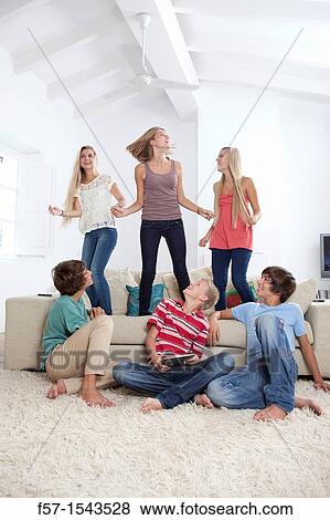 Stock Photo - Group of teenagers dancing to music on a tablet. Fotosearch