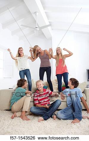 Group of teenagers dancing to music on a tablet View Large Photo Image Stock Photograph - Group of teenagers dancing to music on a tablet. Fotosearch