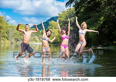 Group of teenagers having summer fun while jumping out of the water View Large Photo Image Stock Photo - Group of teenagers having summer fun while jumping out of the water. Fotosearch