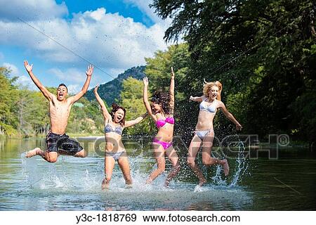 Group of teenagers having summer fun while jumping out of the water View Large Photo Image Stock Photo - Group of teenagers having summer fun while jumping out of the water. Fotosearch