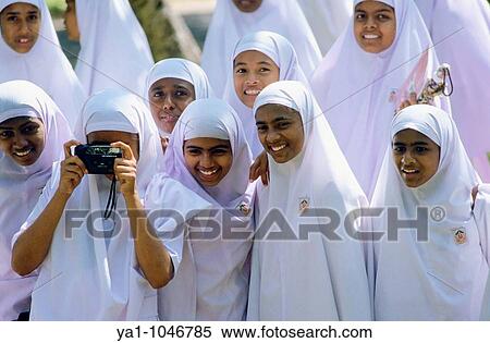 Group of teenagers school girls from a muslim college of Colombo. Viewed in the Paradeniya Royal Botanical Garden garden of Kandy taking picture like tourists with a camera. There are wearing a traditional pink hijab. Sri Lanka island View Large Photo Image Stock Photography - Group of teenagers school girls from a muslim college of Colombo. Viewed in the Paradeniya Royal Botanical Garden garden of Kandy taking picture like tourists with a camera. There are wearing a traditional pink hijab. Sri Lanka island. Fotosearch