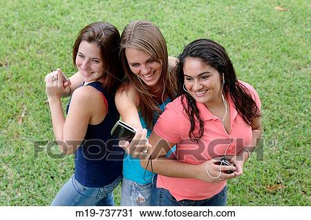 Stock Image - Group of teens taking a picture or themselves. Fotosearch