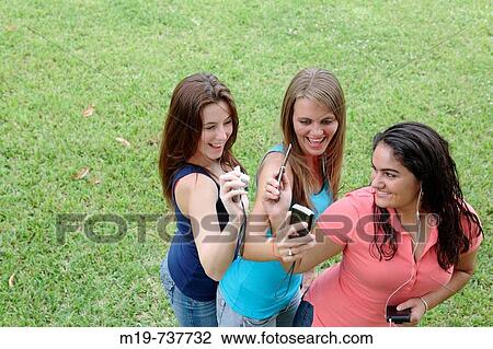 Stock Image - Group of teens taking a picture or themselves. Fotosearch