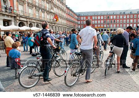 Stock Photo - Group of tourists riding bikes, Main Square. Madrid, Spain.. Fotosearch