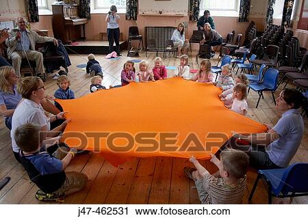 Group of under 4's at nursrey sitting on the floor stretching out a big piece of lycra View Large Photo Image Stock Image - Group of under 4's at nursrey sitting on the floor stretching out a big piece of lycra. Fotosearch