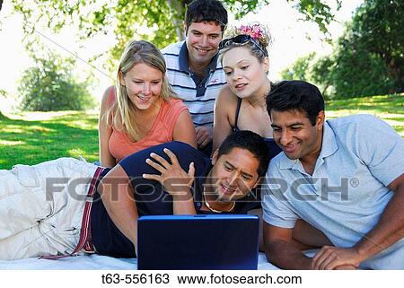 group of young adults using laptop computer together View Large Photo Image Stock Image - group of young adults using laptop computer together. Fotosearch