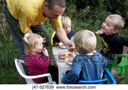 Group of young children having a picnic in the garden View Large Photo Image Stock Photo - Group of young children having a picnic in the garden. Fotosearch