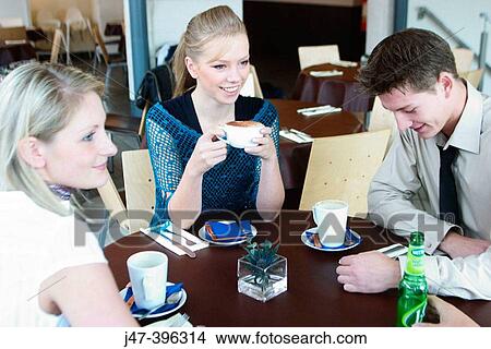 Group of young people, smiling, having a chat in a caf? View Large Photo Image Picture - Group of young people, smiling, having a chat in a caf?. Fotosearch