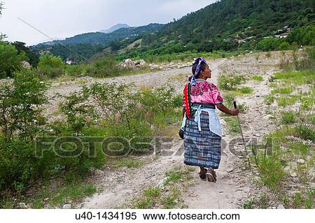 Stock Photography - Guatemala, Mayan woman walking on dirt road. Fotosearch