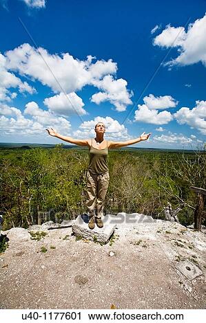 Stock Image - Guatemala, Peten, El Mirador, woman with outstretched arms. Fotosearch