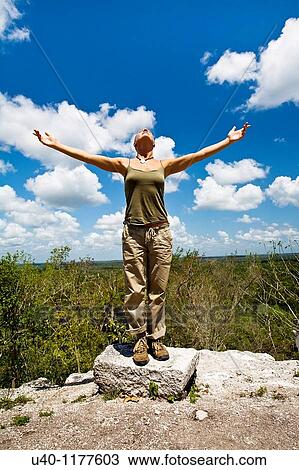 Stock Image - Guatemala, Peten, El Mirador, woman with outstretched arms. Fotosearch