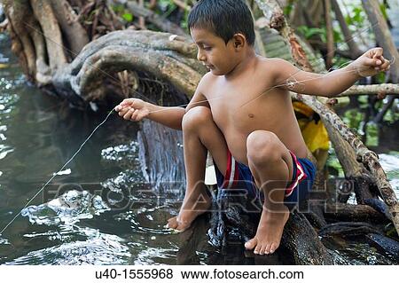 Stock Photo - Guatemala, Rio Dulce, boy fishing in river. Fotosearch