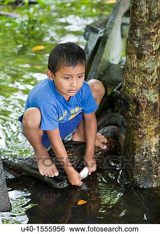 Stock Photograph - Guatemala, Rio Dulce, boy with small fish. Fotosearch