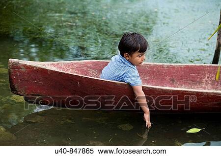 Stock Photography - Guatemala, Rio Dulce, young boy in canoe. Fotosearch