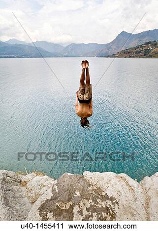 Stock Image - Guatemala, San Marcos La Laguna, man jumping off cliff. Fotosearch