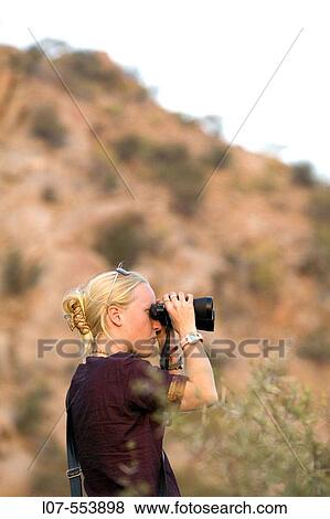 Stock Photo - Guide looking out with binoculars. Bhenswara. Rajasthan. India. Fotosearch