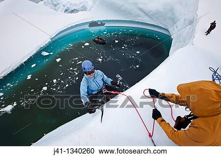 Guide lowers climbers to base of iceberg, ice climbing on grounded iceberg, Cruise ship passengers look on, Pleneau Island, Antarctic Peninsula. View Large Photo Image Stock Image - Guide lowers climbers to base of iceberg, ice climbing on grounded iceberg, Cruise ship passengers look on, Pleneau Island, Antarctic Peninsula.. Fotosearch