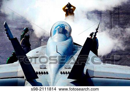 Picture - GULF OF OMAN (Nov. 22, 2009) A flight deck director signals an F/A-18F Super Hornet assigned to the Black Aces of Strike Fighter Squadron (VFA) 41 onto catapult one aboard the aircraft carrier USS Nimitz (CVN 68).. Fotosearch